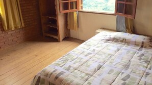 A room with a bed, a wooden wardrobe, and a window with curtains. - White Mountain (Conceição da Ibitipoca)