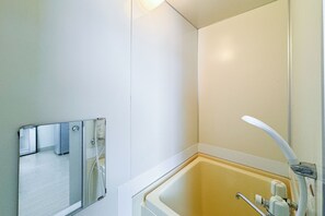 A bathroom with a bathtub, a mirror, and a shower. - ehoraizunkita2jo (Sapporo)
