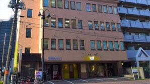 A multi-story hotel with a modern design, featuring a ground-level entrance and a visible sign for a restaurant. - Sapporo East Stay minpaku (Sapporo)