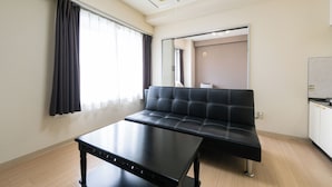 A modern room with a black leather sofa, a black table, and a large mirror. - Sapporo East Stay minpaku (Sapporo)