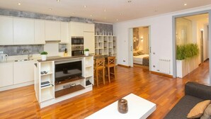 Een modern appartement met keuken, eethoek en woonkamer.