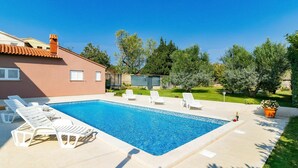 A rectangular swimming pool with white lounge chairs and a potted plant. - Cosy apartment for 4 people with pool, A/C, WIFI, TV and terrace (Pula)