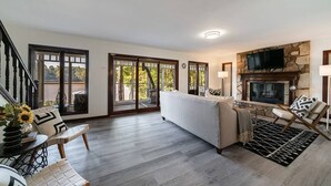 A spacious living room with a fireplace, a sofa, and a coffee table. - LAY Back in the Lake House (Lilburn)