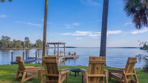 Eine Uferlandschaft mit Holzkreisläufern, einem kleinen Tisch, einer Anlegestelle und einem Gazebo.