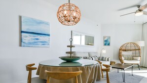 A dining area with a round table, chairs, and a hanging light fixture. - Boho Coastal Condo w/ Free Beach Shuttle at The Palms of Destin! 🐬🐚☀ (Destin)