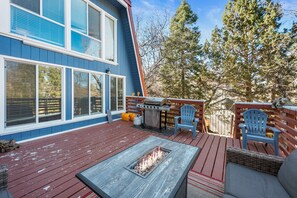 Une terrasse dotée d’un foyer extérieur, de coins salon et d’un barbecue.