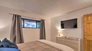 A bedroom with a bed, a dresser, a television, and a window with curtains. - Santa Fe Bungalow ~ 2 Mi to Downtown! (Santa Fe)