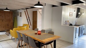 Een moderne keuken met een eethoek, met een houten tafel, stoelen en hanglampen.