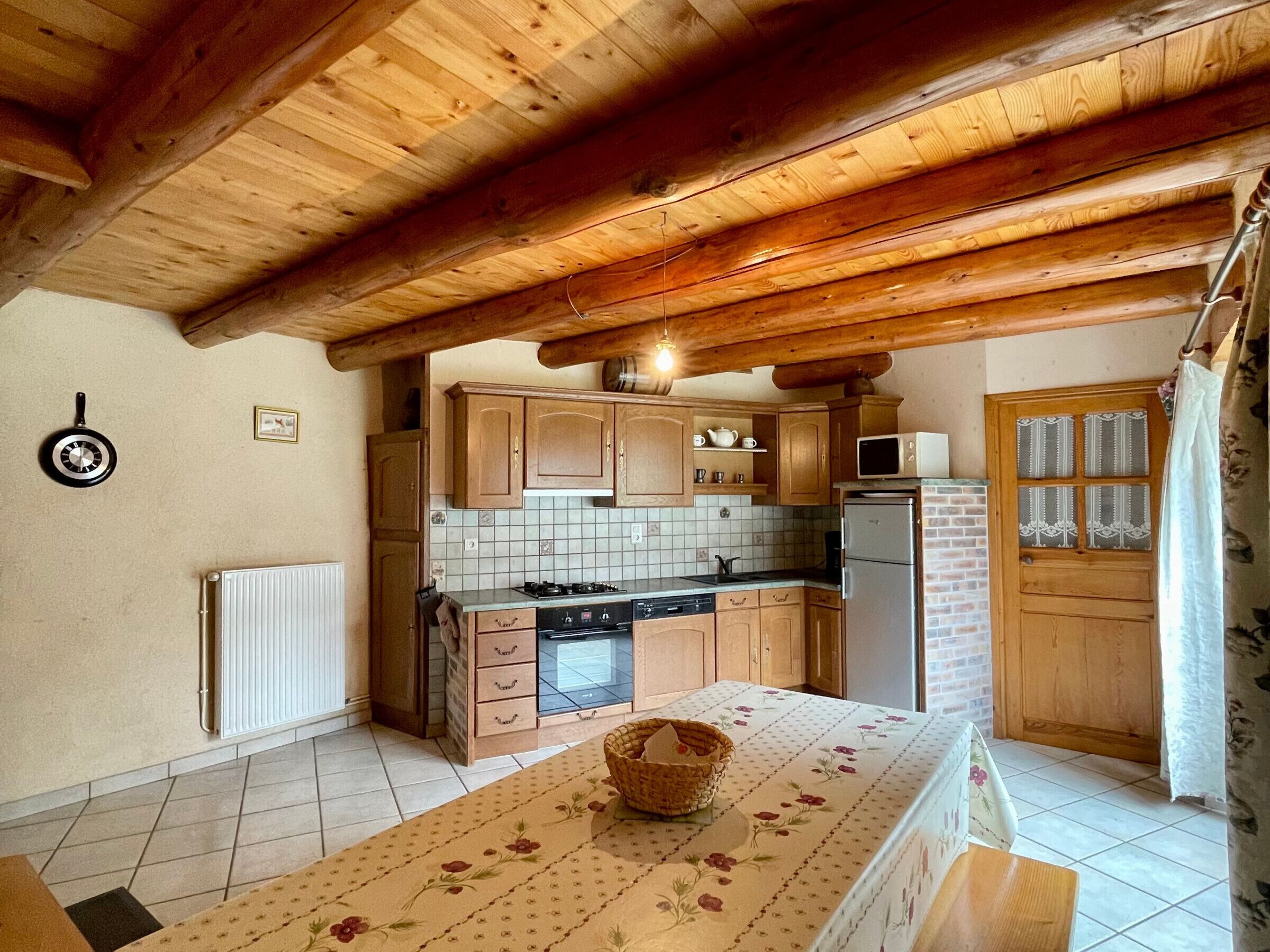 A kitchen with wooden cabinets, a tiled backsplash, a stove, a refrigerator, and a microwave.
