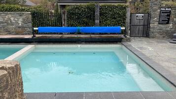 Una piscina al aire libre, una piscina climatizada