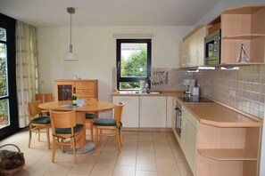Une cuisine compacte avec un coin repas, une fenêtre offrant une belle vue et un four à micro-ondes.
