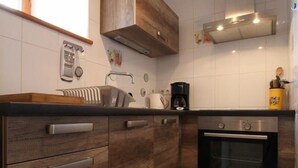 Kjøleskap, mikrobølgeovn, oppvaskmaskin og høy barnestol