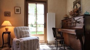 Une pièce avec un sol à carreaux, un fauteuil à rayures, un bureau en bois et une lampe.