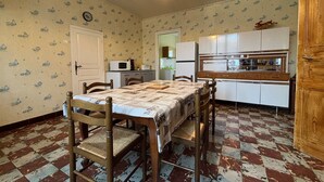 Un coin repas avec une table et des chaises, une cuisine équipée et un papier peint à motifs.