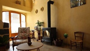 Una sala acogedora con chimenea, una mesa redonda y asientos cómodos.