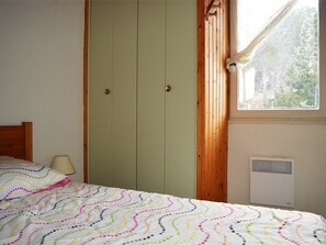 Ein Schlafzimmer mit Bett, Fenster und Heizkörper.
