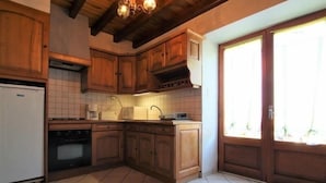 A kitchen with wooden cabinets, a white refrigerator, a microwave, and a sink.