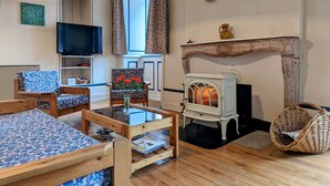 A cozy living room with a fireplace, a television, and a comfortable seating area.