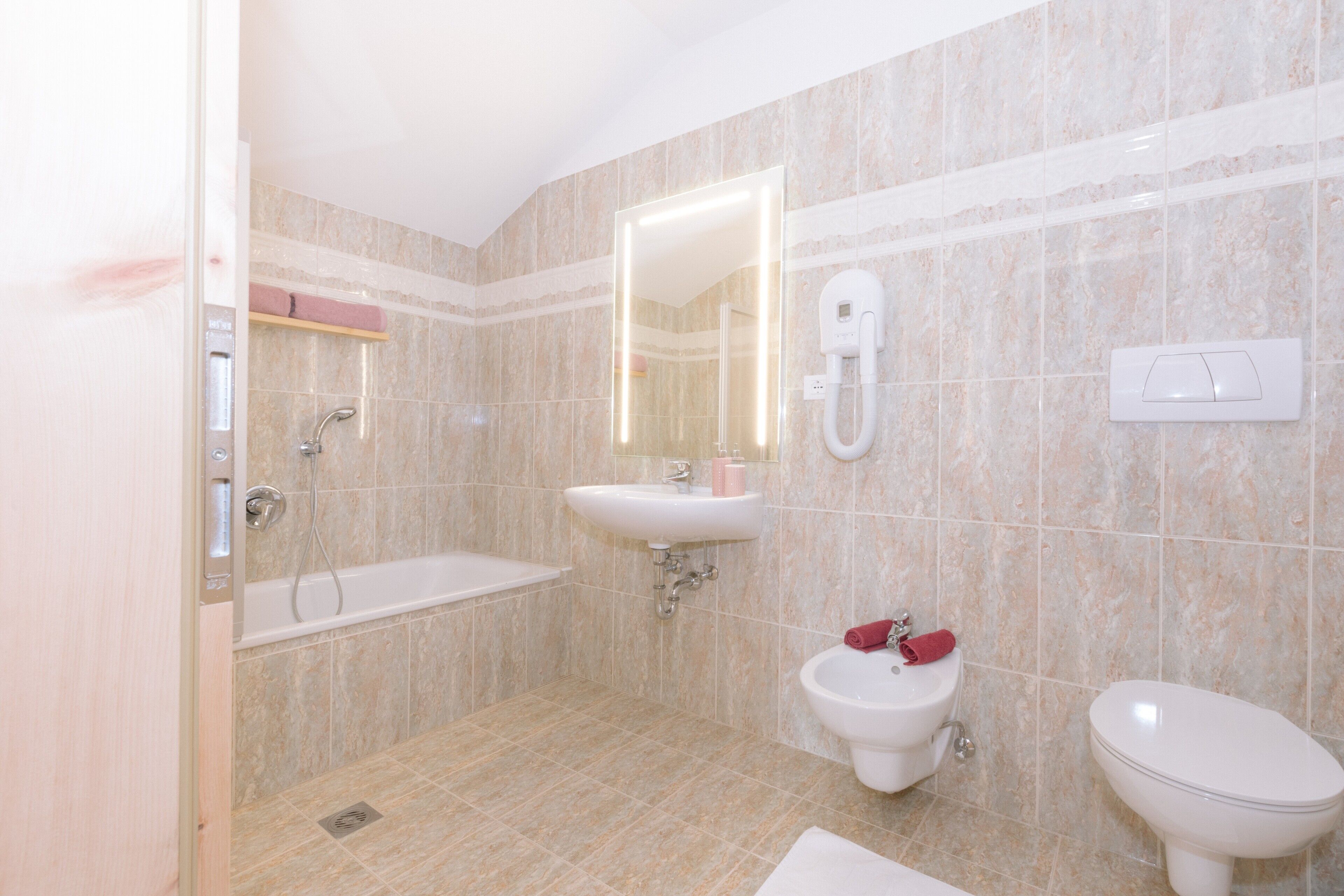 Un baño con bañera, lavabo, bidé e inodoro.