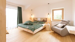 A bedroom with a bed, a chair, a window, and a headboard. - Holiday Home “Wies Wieserhof” with Mountain View, Balcony and Shared Garden (Aldein)