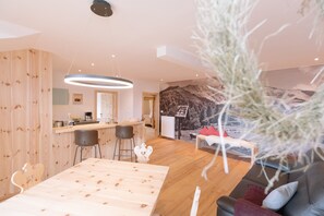 Un interior moderno con una mesa de comedor de madera, una zona de bar y un sofá.