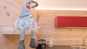 Et køkken med trævægge, et rødt skab og et ophængt viskestykke.