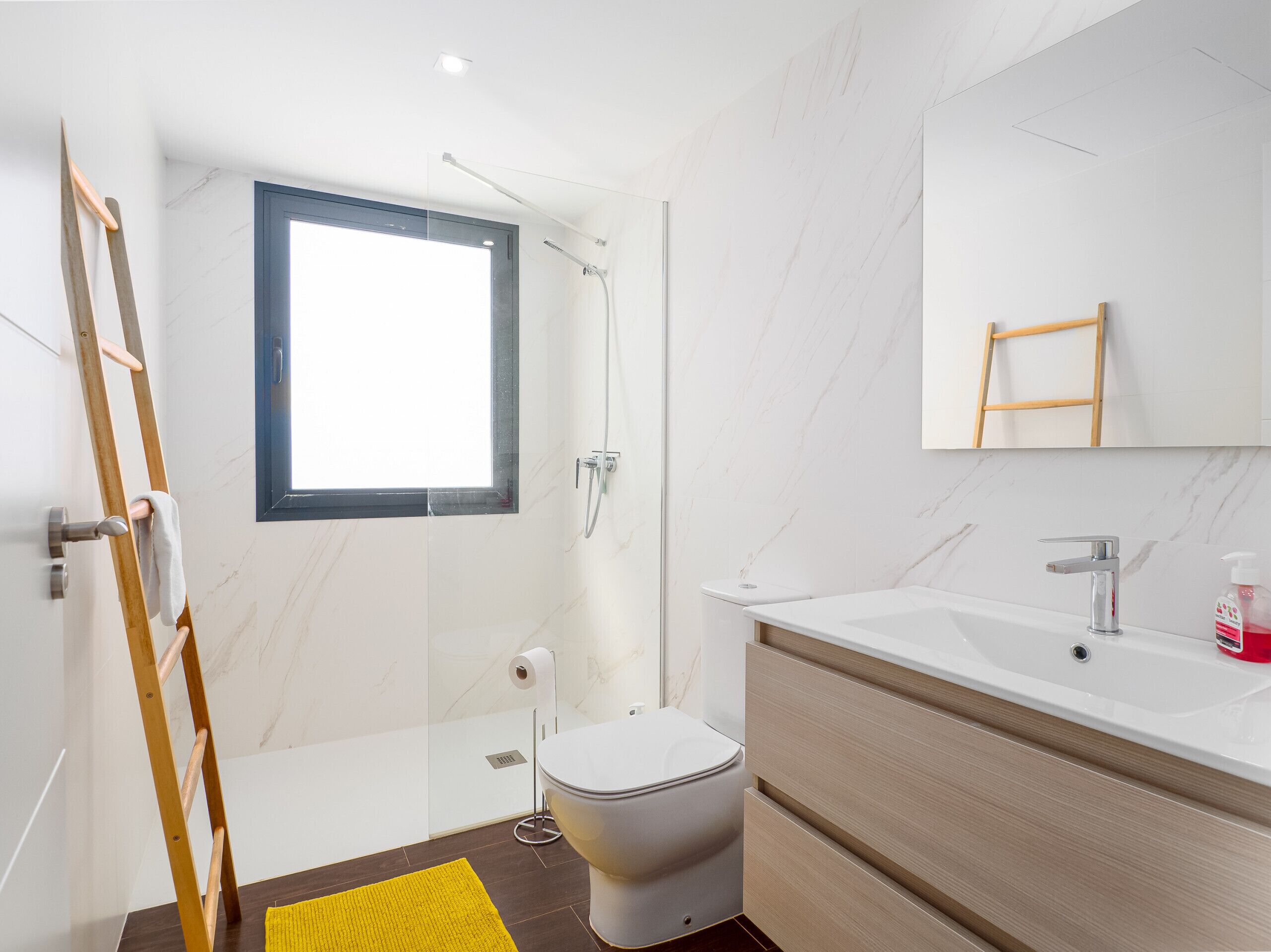 Une salle de bain moderne équipée d’une douche, de toilettes et d’un lavabo.