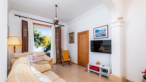 Un salon avec un canapé, un fauteuil, un téléviseur et une cheminée.