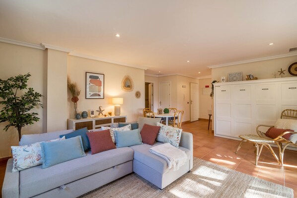 A living room with a sofa, a dining table, and a cabinet.