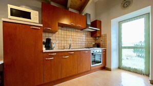 Une cuisine avec des meubles de rangement en bois, un four à micro-ondes, une cuisinière et une fenêtre donnant sur un beau paysage.