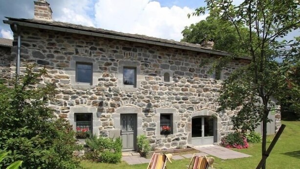 A stone building with a garden, two lounge chairs, and a wooden bench. - Restored 19th-Century Farmhouse with Garden, Near Trails & Attractions (Saint-Julien-Chapteuil)
