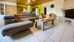 A modern living room with a sectional sofa, a fireplace, and a dining area.