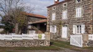 A stone building with a white picket fence, a small window, and a chimney. - Charming House with Terrace, Garage, and Activities near Allier Gorges (Mazeyrat-d'Allier)