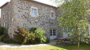 A stone building with a small window, a door, and a picnic table in the yard. - Charming Village Farmhouse Sleeps 8 – Near Allier Gorges & Pradelles (Rauret)