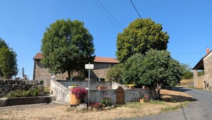 A rural street with stone buildings, a signpost, and a clear blue sky. - Charming Village Farmhouse Sleeps 8 – Near Allier Gorges & Pradelles (Rauret)