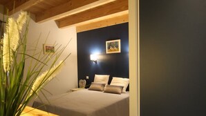 A bedroom with a bed, bedside table, and a wall-mounted light. - Cozy 5-bedroom lodge near Freycenet-la-Cuche, perfect for families and friends, pet-friendly (Freycenet-la-Cuche)