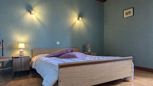 Una camera da letto con un letto in legno, due lampade ai comodini e un quadro appeso alla parete.