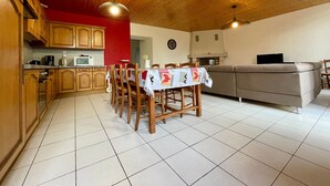 Une cuisine chaleureuse avec des meubles de rangement en bois, une table à manger et un canapé.