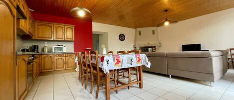 Una cocina acogedora con armarios de madera, una mesa de comedor y un sofá.