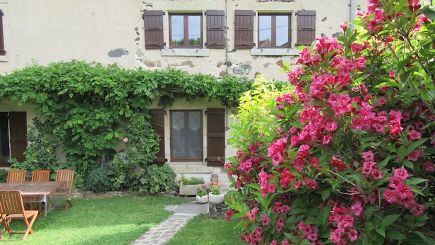 A rustic building with a garden, a stone pathway, and wooden furniture. - Restored farmhouse with enclosed garden and terrace, near Puy en Velay (Le Monastier-sur-Gazeille)