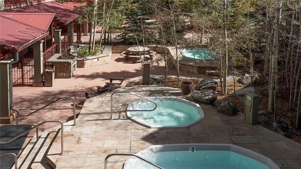 Un espace bien-être comprenant deux bains à remous, un coin salon extérieur et une piscine.
