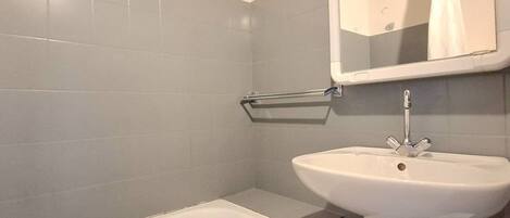 A bathroom with a bathtub, a sink, and a mirror.