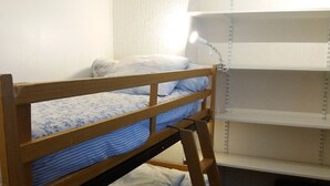 A bunk bed with a wooden frame, a desk with a lamp, and a window with blinds. - Cozy 2-Room Apartment with Cabin for 6, Near Shops and 800m from Ski Slopes (Bolquère-Superbolquère)