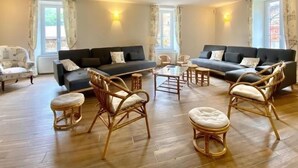Ein geräumiges Wohnzimmer mit zwei Sofas, einem Couchtisch und Korbstühlen.