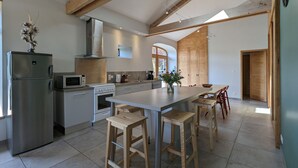 Una cocina moderna con una isla central, vigas de madera y un tragaluz.