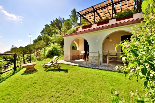 A villa with a patio, outdoor seating, and a garden.