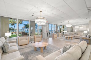 Eine großzügige Lobby mit moderner Einrichtung, großen Fenstern und Blick aufs Meer.