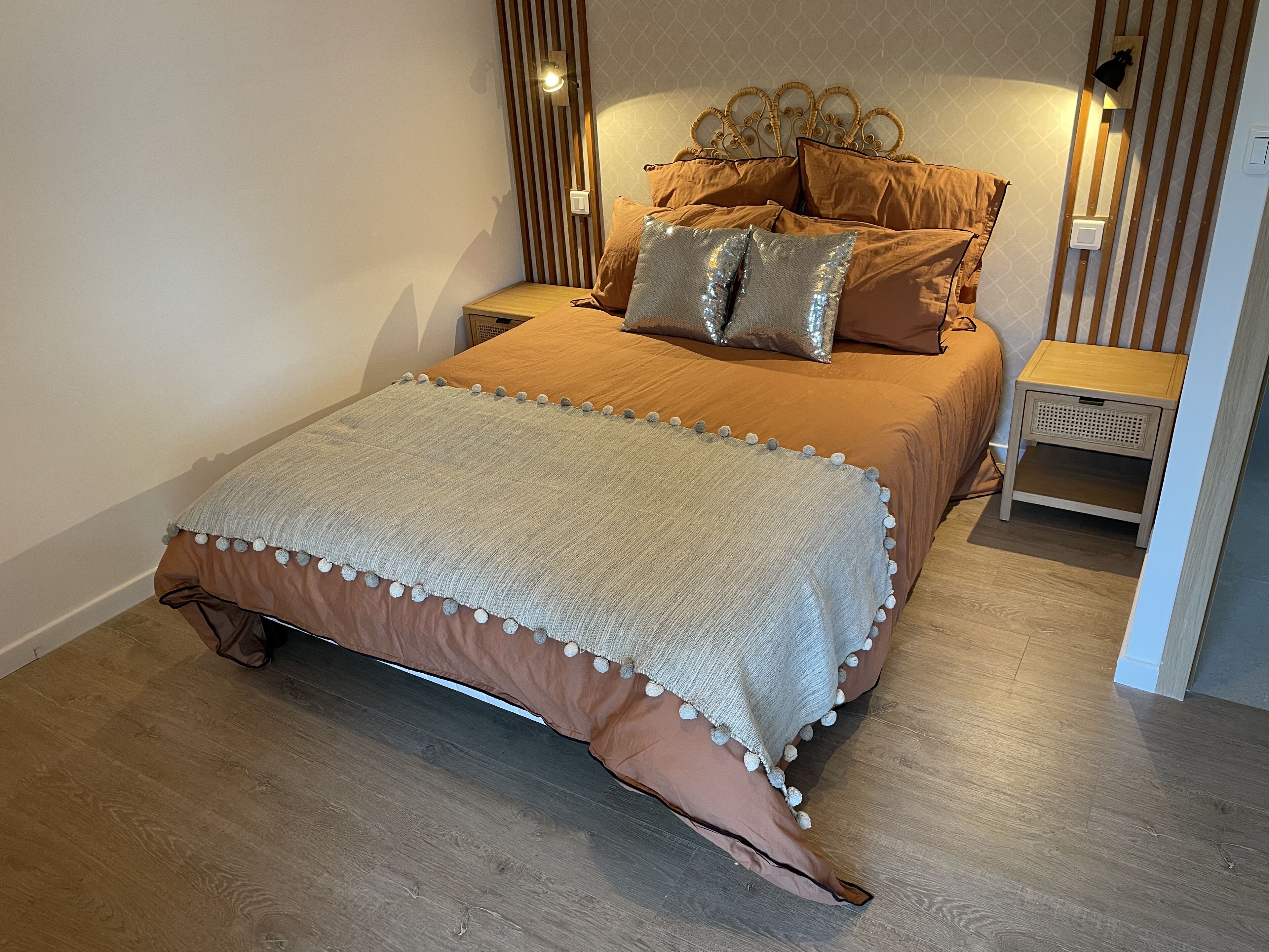 Un dormitorio con cama, mesitas de noche y un velador.