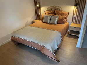 Ein Schlafzimmer mit einem Bett, Nachttischen und einem Beistelltisch.