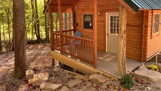 A wooden cabin with a porch, a door, and a window. -     Secluded Log Cabin • Trails • 7 Minutes to French Lick • Pet Friendly (French Lick)